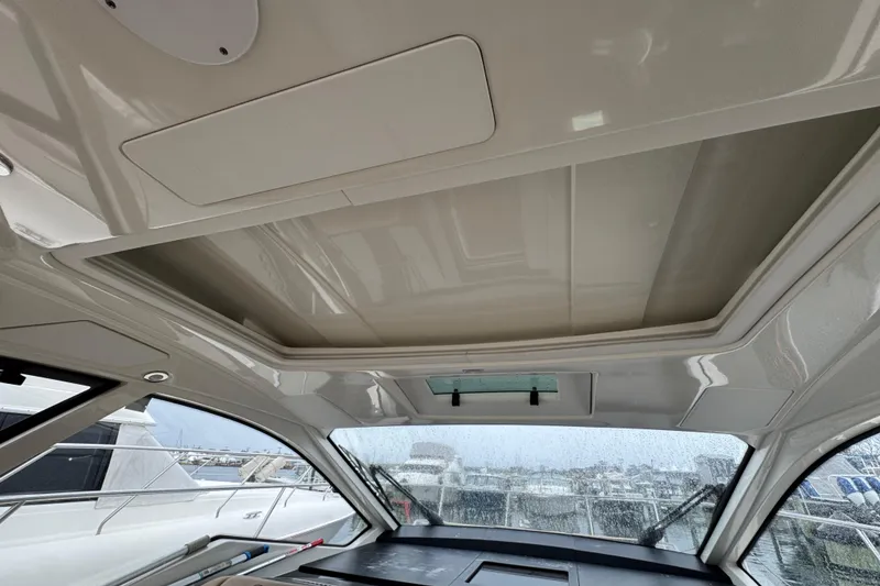 Slide: The Image of 2018 Sea Ray Sundancer 350 Coupe interior with sunroof and marina view. - 39