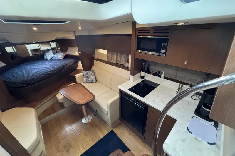 Slide: The Image of Interior of 2018 Sea Ray Sundancer 350 Coupe with kitchen and cozy sleeping area. - 4