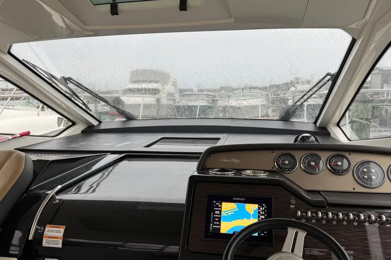 Slide: The Image of 2018 Sea Ray Sundancer 350 Coupe cockpit with navigation system and rain-soaked windshield. - 42