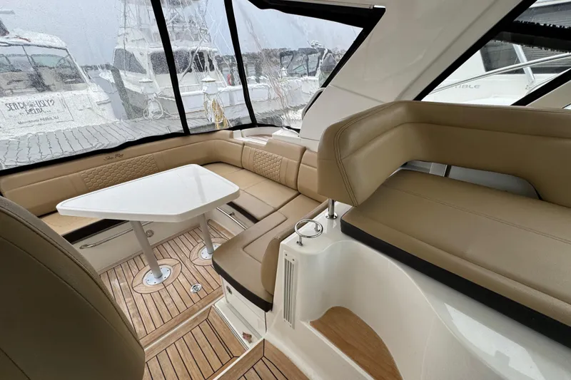 Slide: The Image of 2018 Sea Ray Sundancer 350 Coupe interior with beige seating and white table. - 46