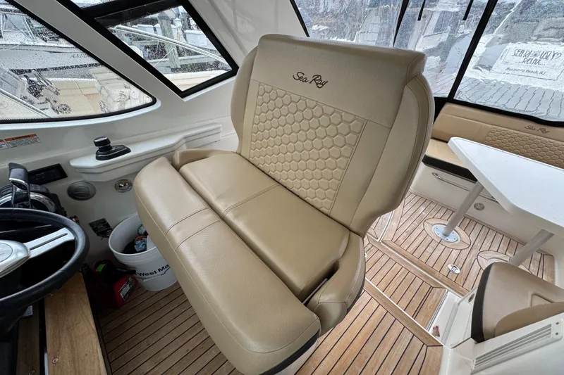 Slide: The Image of 2018 Sea Ray Sundancer 350 Coupe interior with beige seating and wooden flooring. - 49