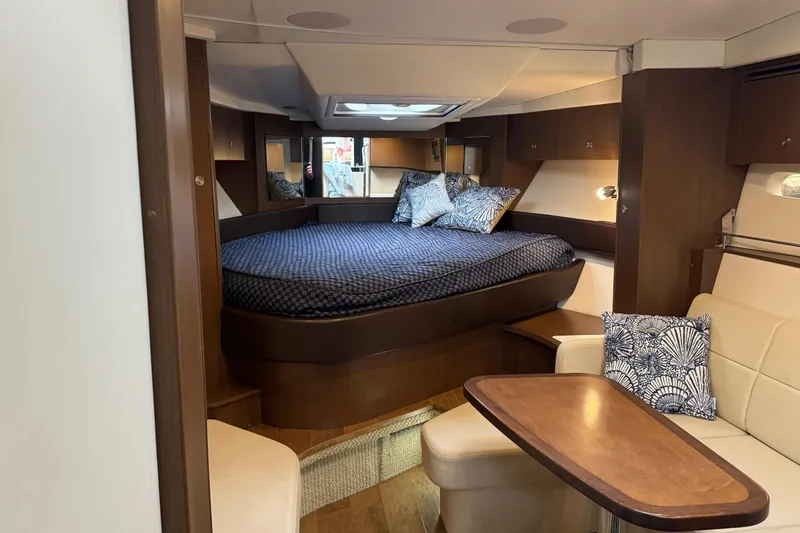 Slide: The Image of 2018 Sea Ray Sundancer 350 Coupe interior with cozy bed and seating area. - 5