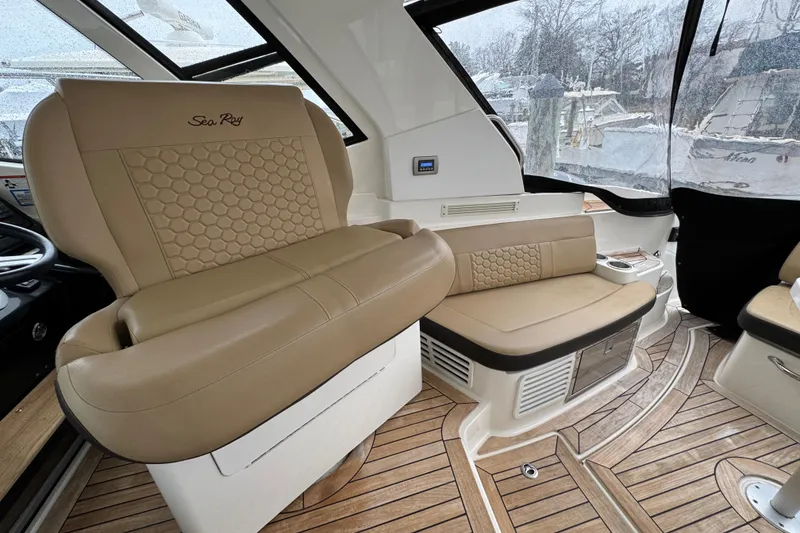 Slide: The Image of 2018 Sea Ray Sundancer 350 Coupe interior with beige seating and wood flooring. - 53
