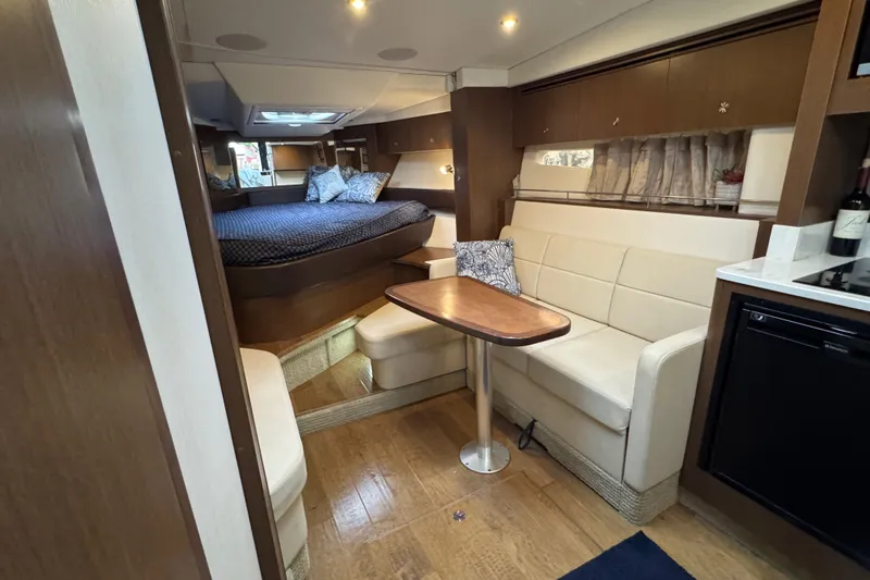 Slide: The Image of 2018 Sea Ray Sundancer 350 Coupe interior with cozy seating and elegant wood finishes. - 6