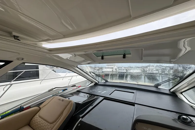 Slide: The Image of Interior view of 2018 Sea Ray Sundancer 350 Coupe, featuring helm and panoramic windows. - 73