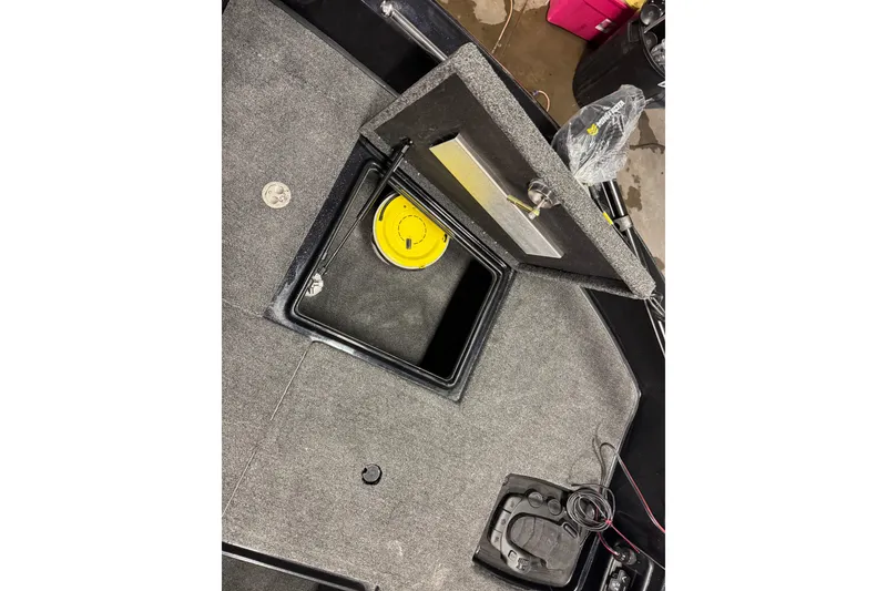 Slide: The Image of Open storage compartment in 2026 Nitro ZV19 Sport boat, featuring a yellow lid and wiring. - 24