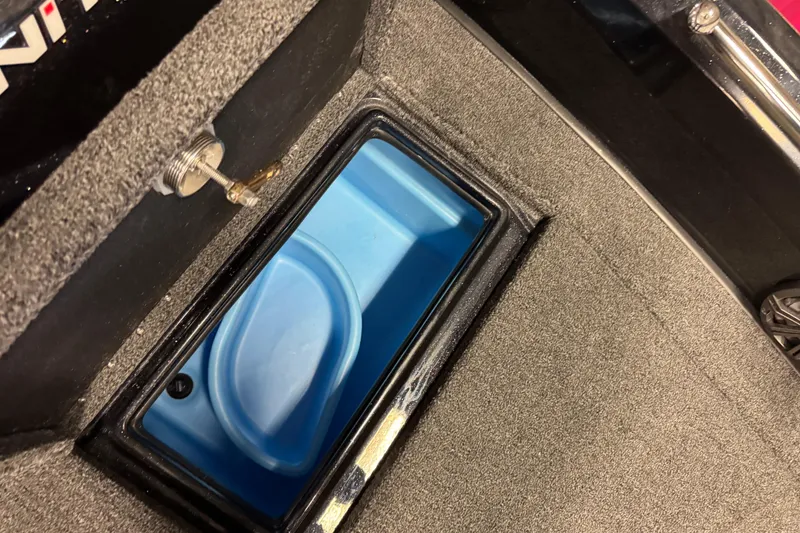 Slide: The Image of 2026 Nitro ZV19 Sport boat storage compartment with blue interior and secure latch. - 26