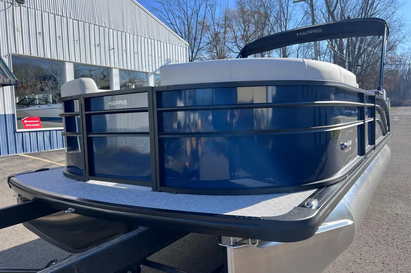 Slide: The Image of 2026 Harris 210 Cruiser SLDH pontoon boat, blue exterior, parked outdoors. - 13