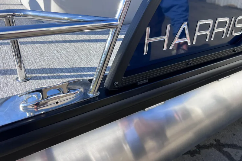Slide: The Image of 2026 Harris 210 Cruiser SLDH pontoon boat, featuring sleek metallic details and branding. - 32