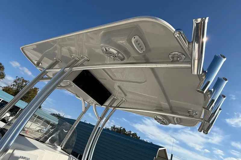 Slide: The Image of 2025 May-Craft 245 Offshore CC boat with T-top and rod holders under clear blue sky. - 5