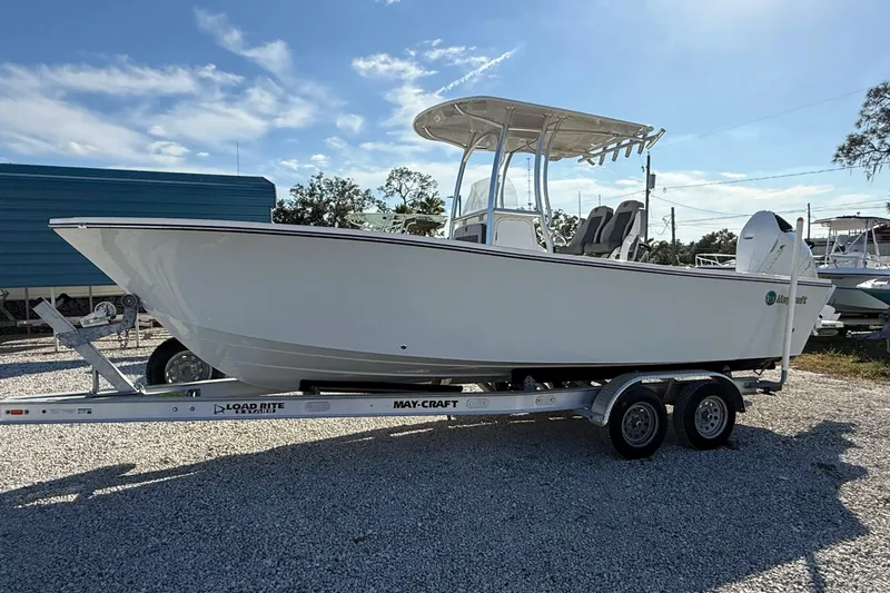 Slide: The Image of 2025 May-Craft 245 Offshore CC boat on trailer, parked outdoors under clear sky. - 1