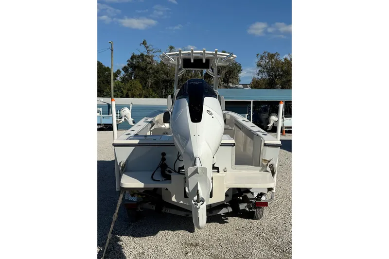 Slide: The Image of 2025 May-Craft 245 Offshore CC boat, rear view with outboard motor, parked on gravel. - 4