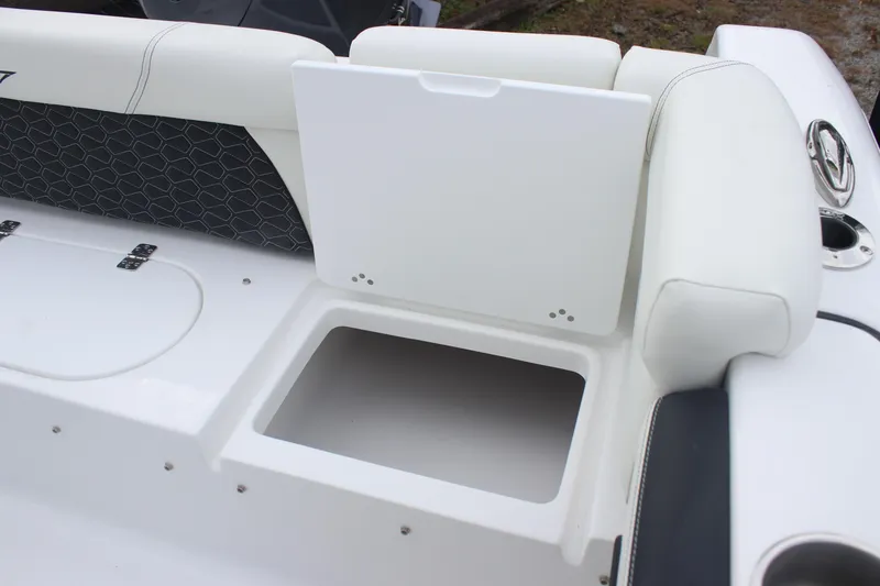 Slide: The Image of 2026 Tidewater 220 LXF boat interior storage compartment with white cushioned seating. - 12