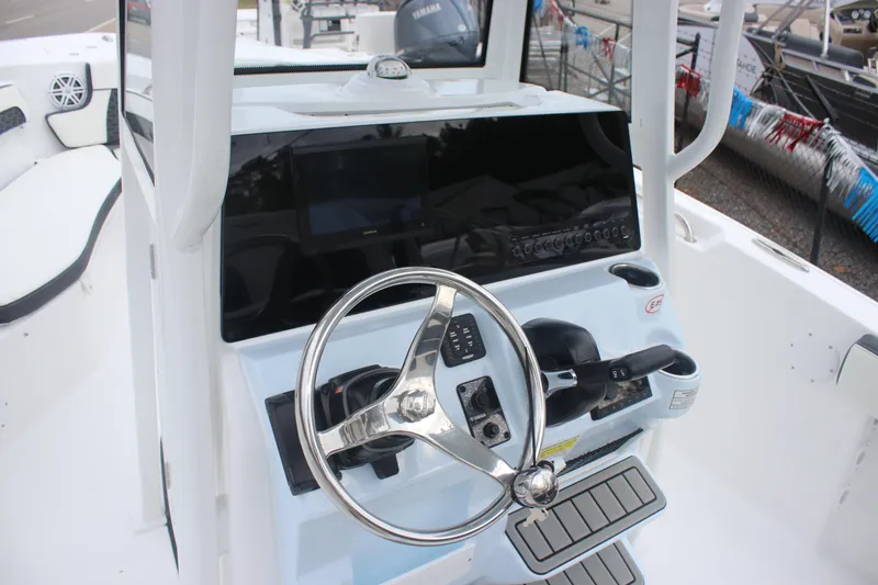 Slide: The Image of 2026 Tidewater 220 LXF boat helm with steering wheel and control panel. - 17