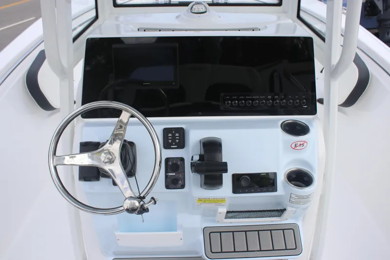 Slide: The Image of 2026 Tidewater 220 LXF boat console with steering wheel, controls, and cup holders. - 6