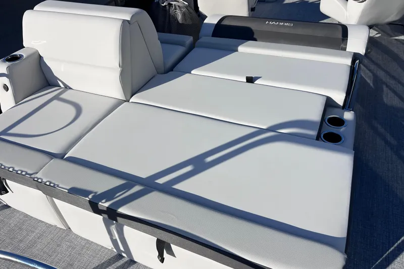Slide: The Image of 2026 Harris Cruiser 230 SLDH Tritoon with luxurious white seating and cup holders. - 26