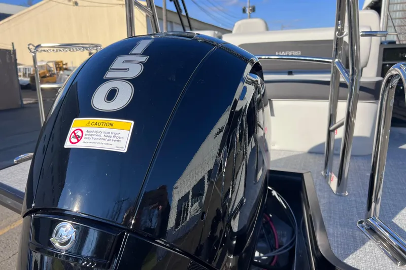 Slide: The Image of 2026 Harris Cruiser 230 SLDH Tritoon with 150 horsepower engine, docked outdoors. - 5