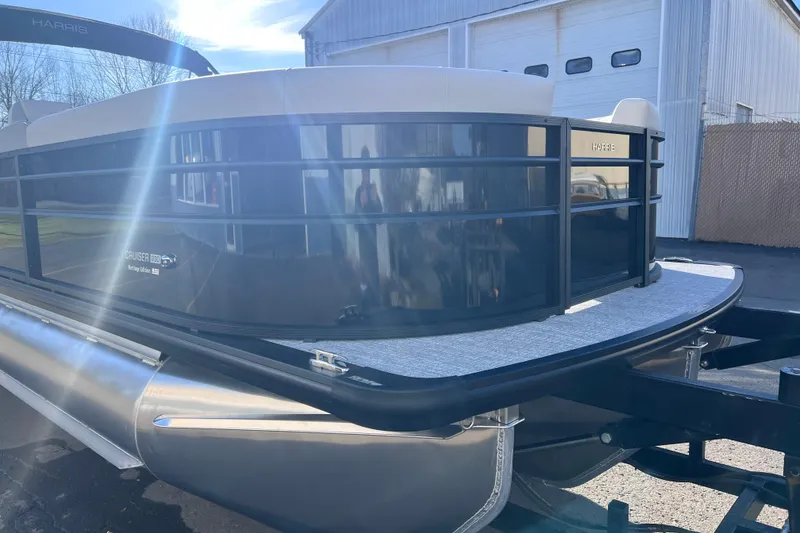 Slide: The Image of 2026 Harris Cruiser 230 SLDH Tritoon boat parked outdoors, showcasing sleek design. - 8