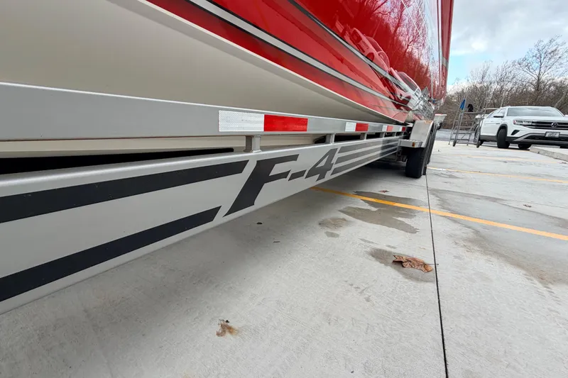 Slide: The Image of 2011 Sunsation F4 boat trailer with red detailing in a parking lot. - 10