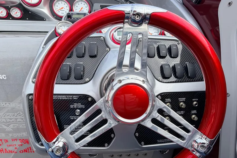 Slide: The Image of Red steering wheel of a 2011 Sunsation F4 boat with dashboard controls and gauges. - 16