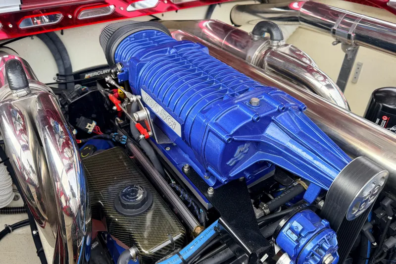 Slide: The Image of Engine of a 2011 Sunsation F4 boat with blue supercharger and chrome exhaust. - 41