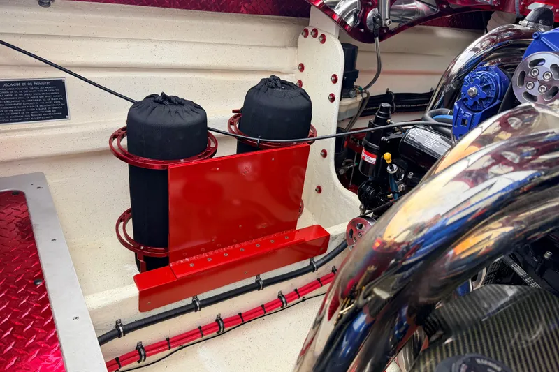 Slide: The Image of Engine compartment of a 2011 Sunsation F4 boat, featuring red and chrome components. - 43