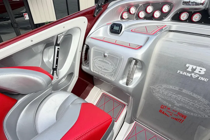 Slide: The Image of 2011 Sunsation F4 boat interior with red and silver seating, dashboard gauges, and custom decals. - 49