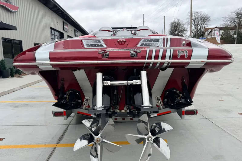 Slide: The Image of 2011 Sunsation F4 boat with dual propellers, parked on concrete near a building. - 5