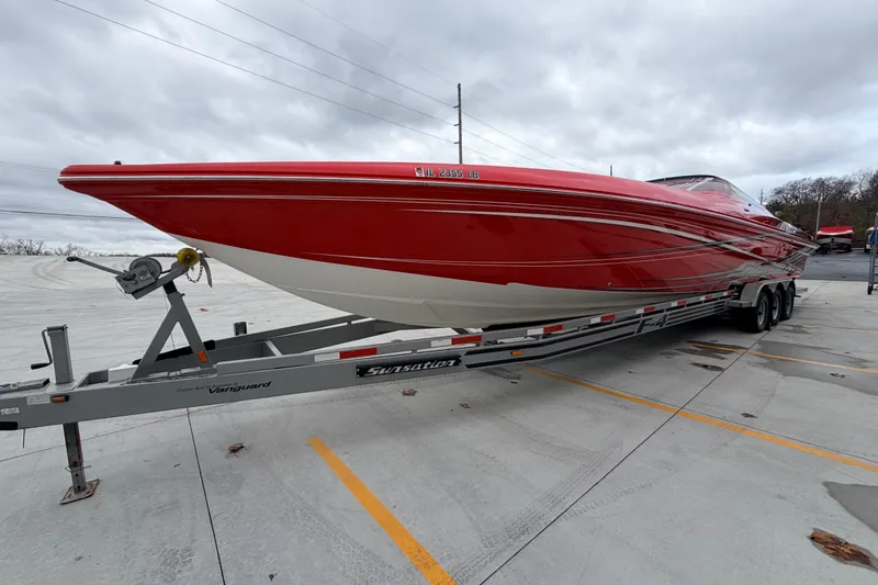 Slide: The Image of 2011 Sunsation F4 powerboat in vibrant red on a trailer, parked outdoors. - 8