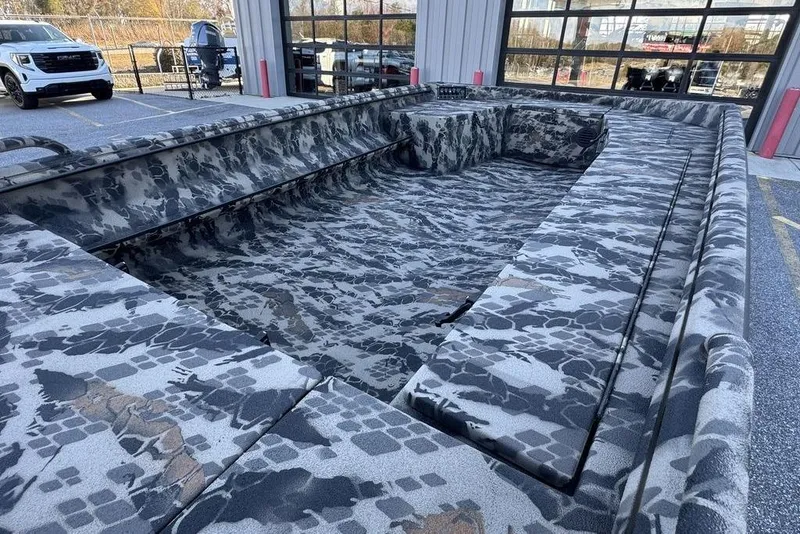 Slide: The Image of Camouflage-patterned 2025 Havoc 1860 boat displayed outdoors near a garage. - 13