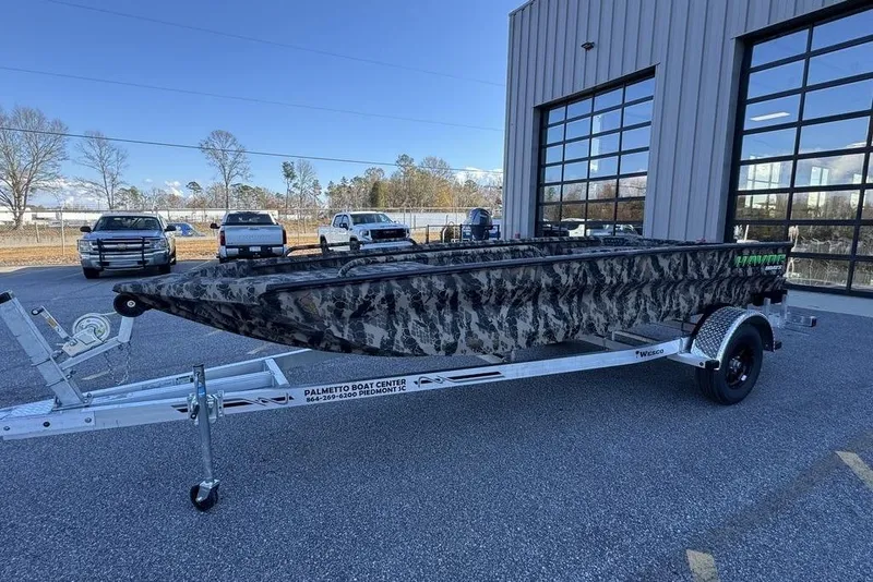 Slide: The Image of 2025 Havoc 1860 boat with camouflage design on a trailer outside a dealership. - 4