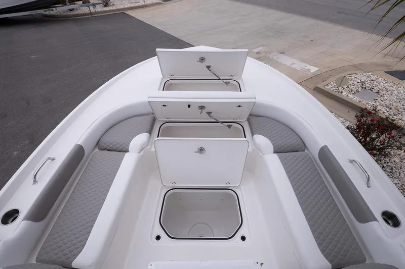 Slide: The Image of 2026 Caymas 24 HB boat interior with open storage compartments and cushioned seating. - 19