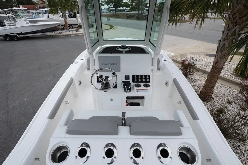 Slide: The Image of 2026 Caymas 24 HB boat interior with steering console and seating, featuring Garmin electronics. - 9