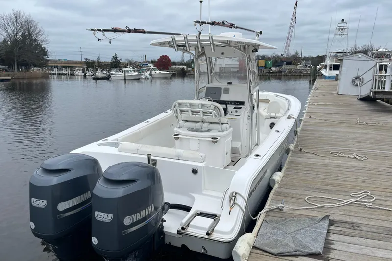 Slide: The Image of 2014 Sportsman Heritage 251 Center Console boat docked with twin Yamaha engines. - 2