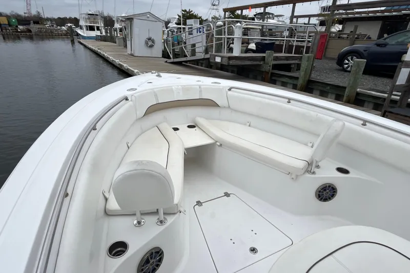Slide: The Image of 2014 Sportsman Heritage 251 Center Console boat with white seating at a marina. - 4