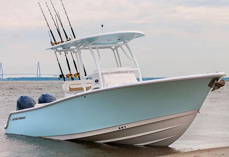 Slide: The Image of Manufacturer Provided Image: 2014 Sportsman Heritage 251 Center Console boat on the shore with fishing rods. - 6
