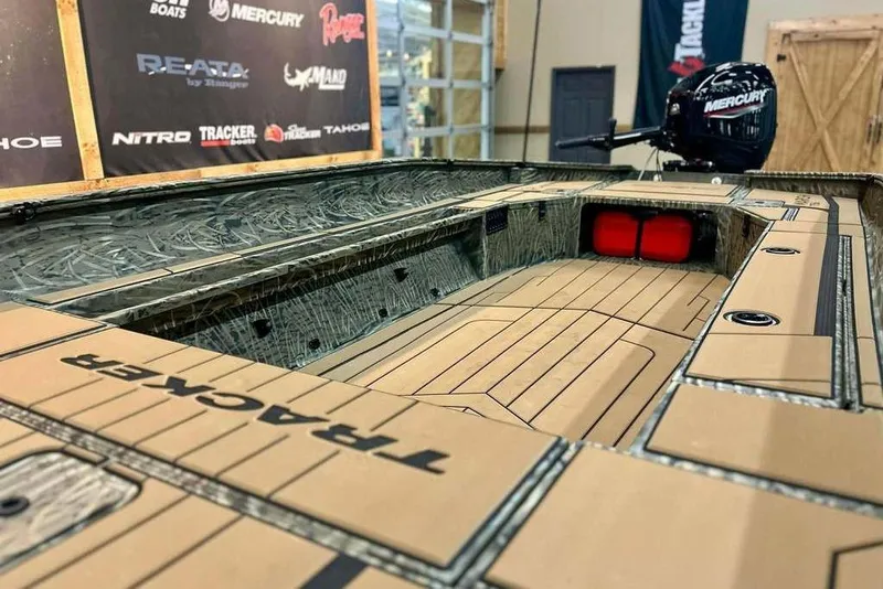 Slide: The Image of 2026 Tracker Grizzly 1756 T Marsh boat interior with Mercury engine, showcased at an event. - 13