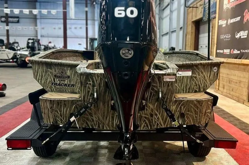 Slide: The Image of 2026 Tracker Grizzly 1756 T Marsh boat with camo design and 60 HP engine in showroom. - 6