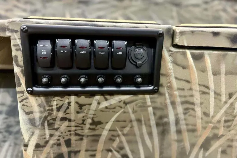 Slide: The Image of Control panel of 2026 Tracker Grizzly 1756 T Marsh boat with switches and 12V outlet. - 8