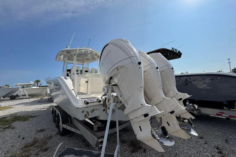 Slide: The Image of 2022 Cobia 350 Center Console boat with triple outboard engines on a trailer. - 10