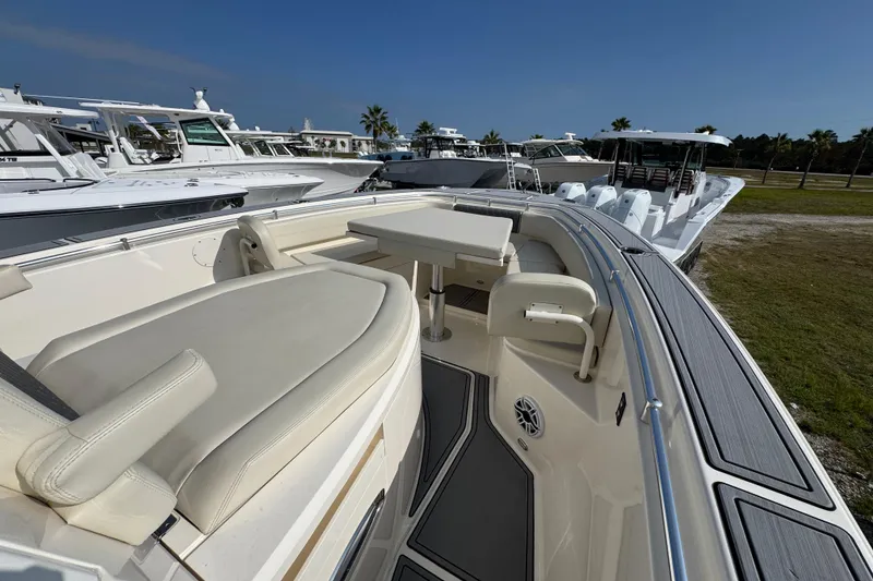 Slide: The Image of 2022 Cobia 350 Center Console boat with seating and table, docked under clear skies. - 12
