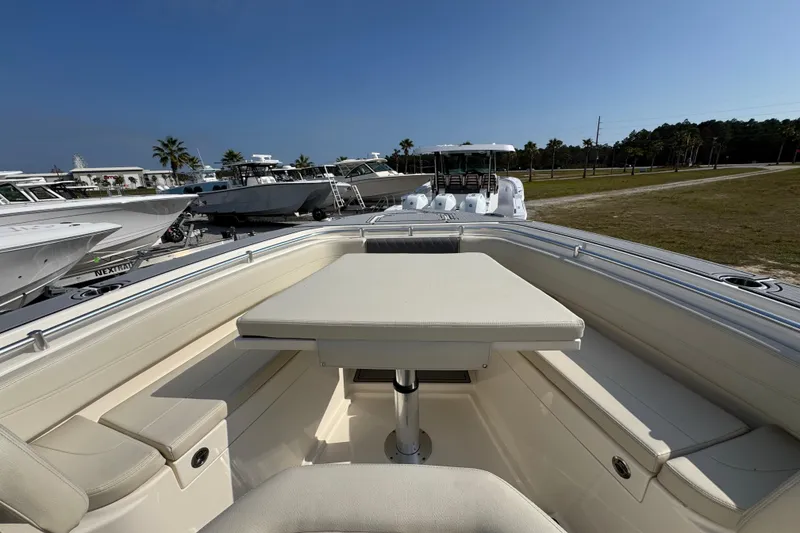 Slide: The Image of 2022 Cobia 350 Center Console boat with spacious seating and table, docked outdoors. - 13