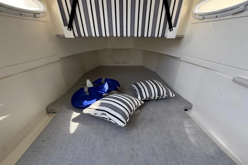 Slide: The Image of 2022 Cobia 350 Center Console cabin interior with striped cushions and life jacket. - 25