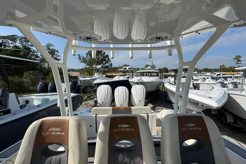 Slide: The Image of 2022 Cobia 350 Center Console boat interior with seating and helm, surrounded by other boats. - 28