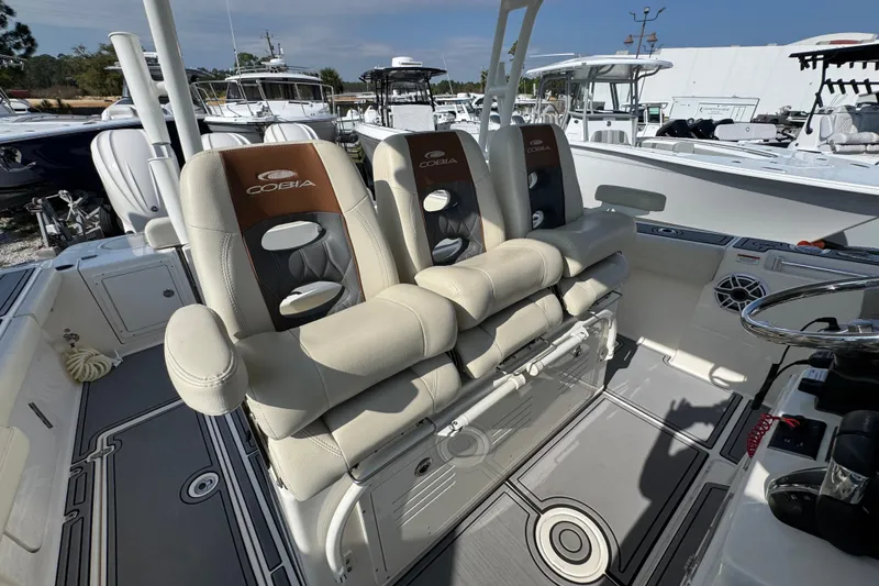 Slide: The Image of 2022 Cobia 350 Center Console boat interior with cushioned seating and steering wheel. - 34
