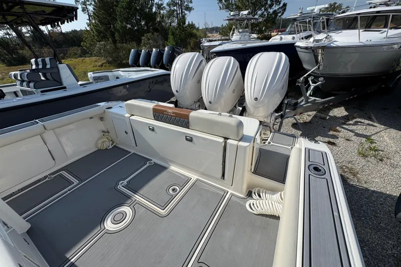 Slide: The Image of 2022 Cobia 350 Center Console boat with triple outboard engines, docked outdoors. - 39
