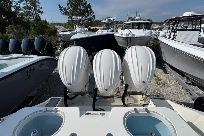 Slide: The Image of 2022 Cobia 350 Center Console with triple outboard engines in a boatyard. - 41