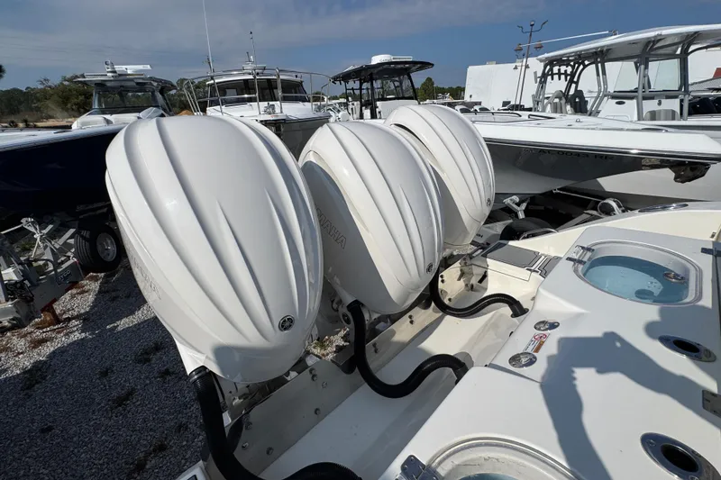 Slide: The Image of 2022 Cobia 350 Center Console with triple Yamaha outboard engines, docked in a marina. - 43