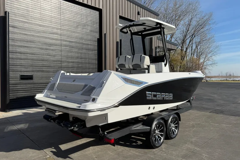 Slide: The Image of 2026 Scarab 235 Open SE boat on trailer, parked near a modern building. - 4