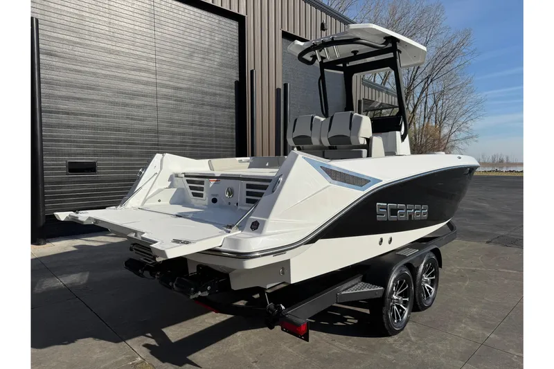 Slide: The Image of 2026 Scarab 235 Open SE boat on trailer, parked outdoors near a building. - 5